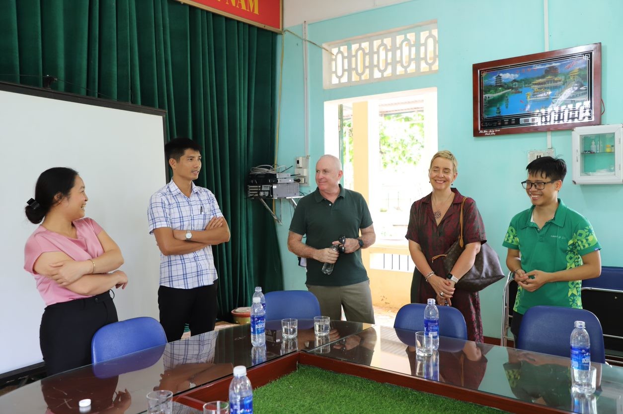 The group chatting with the principal of Trung Hoa Primary & Secondary school in pink