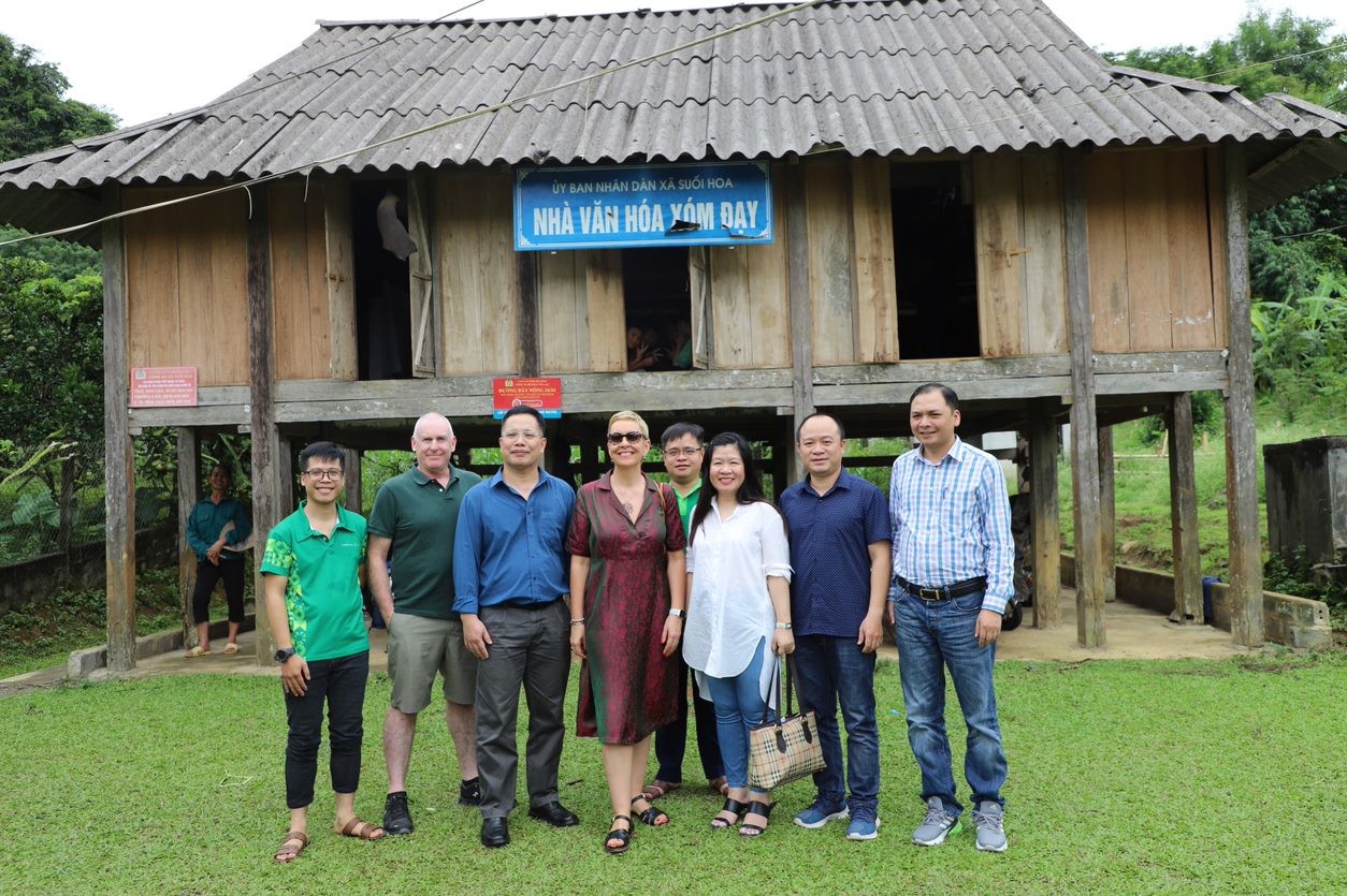 The group outside a stilt house where children are participating in the communication event of Swipe Safe project